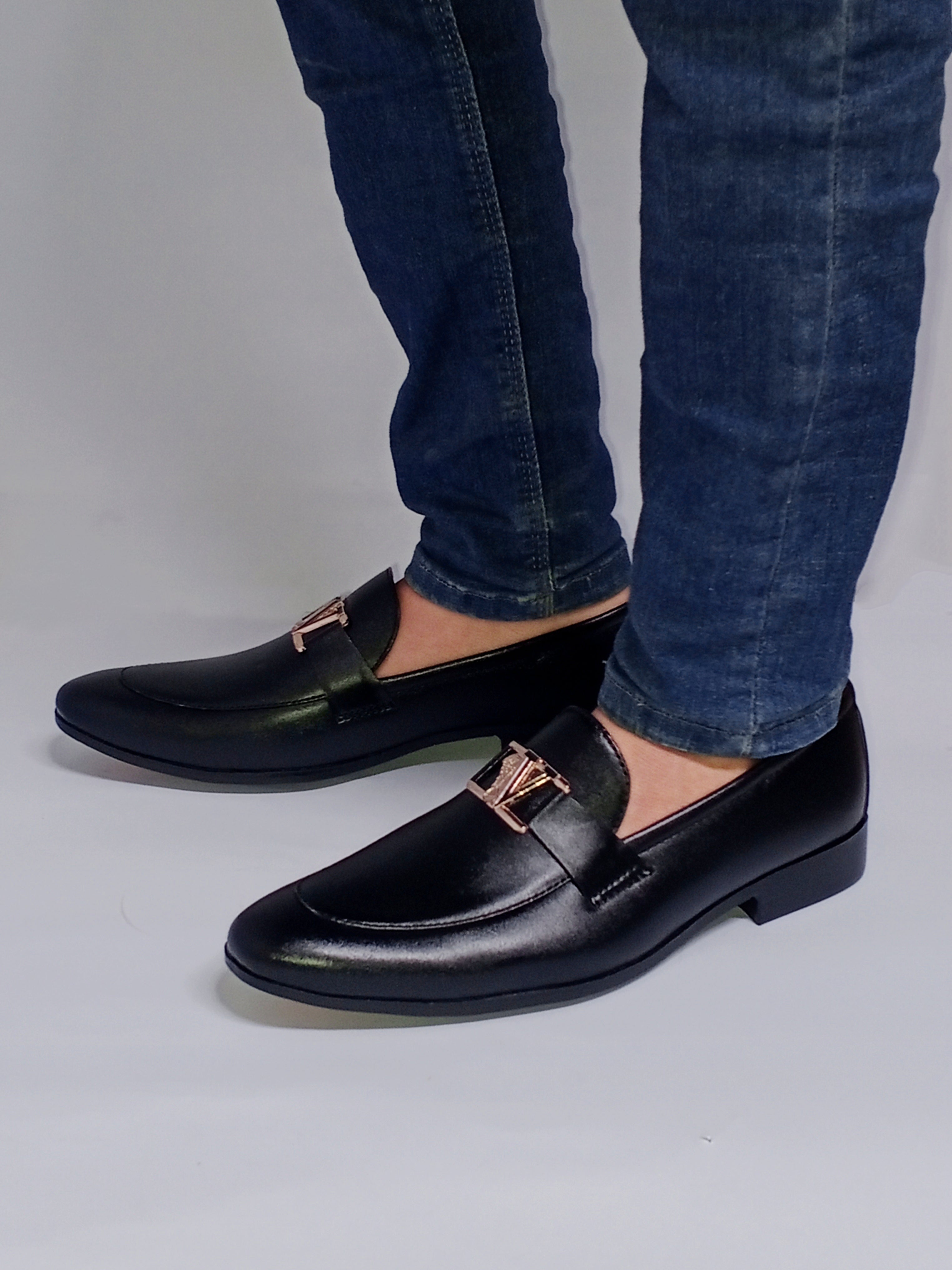 Black  Pumpy : A pair of sleek black  Pumpy with center buckle a minimalist design